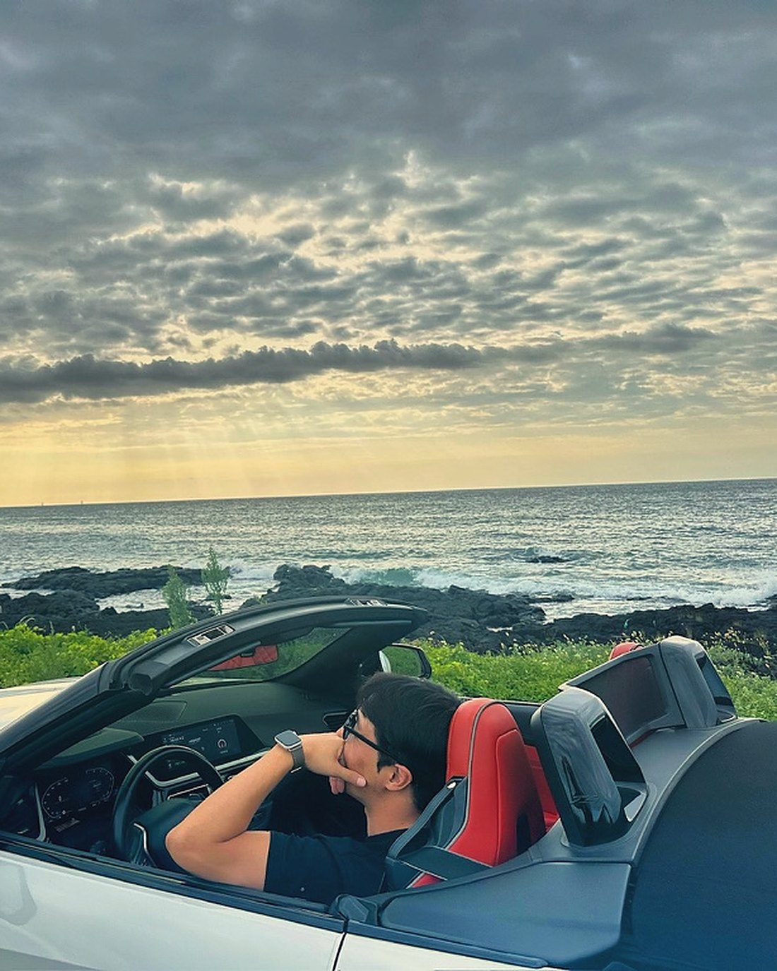 from. JAKE in a convertible by the sea at golden hour