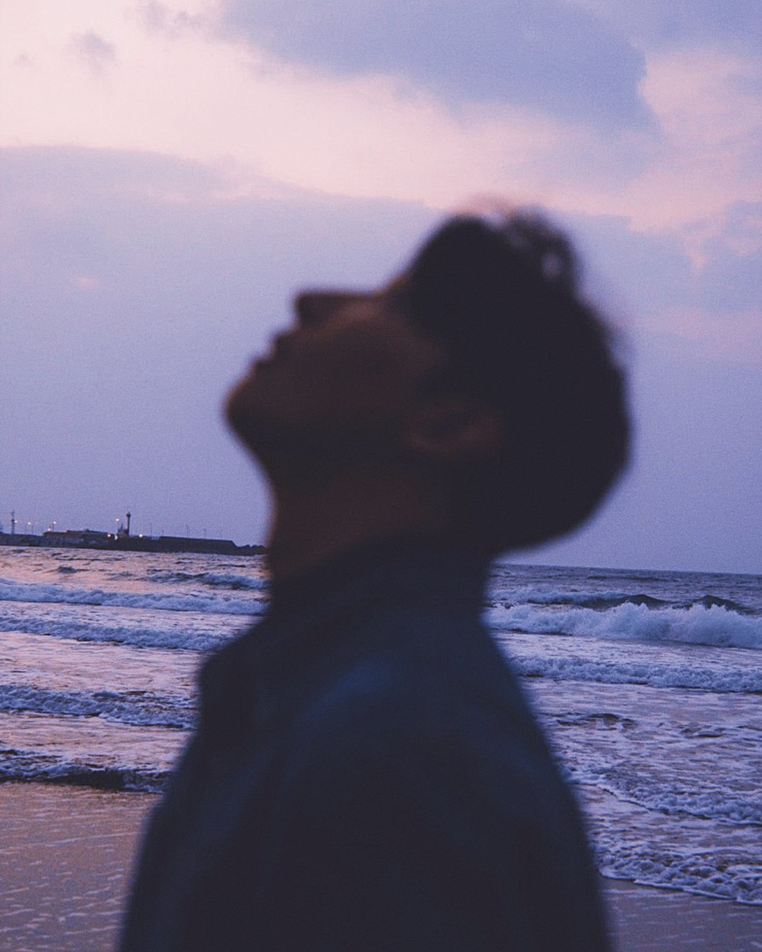 from. JAKE looking up at a violet dusk sky by the sea