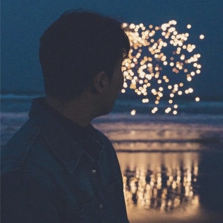 Looking out over the sea as fireworks burst at night