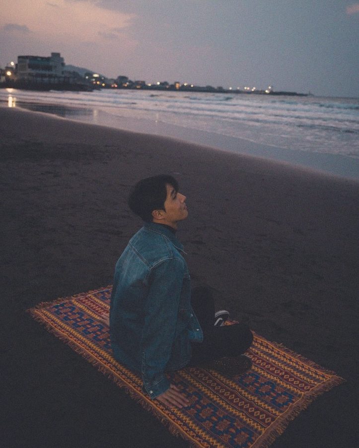 Sitting on a woven rug as the sky turns pink